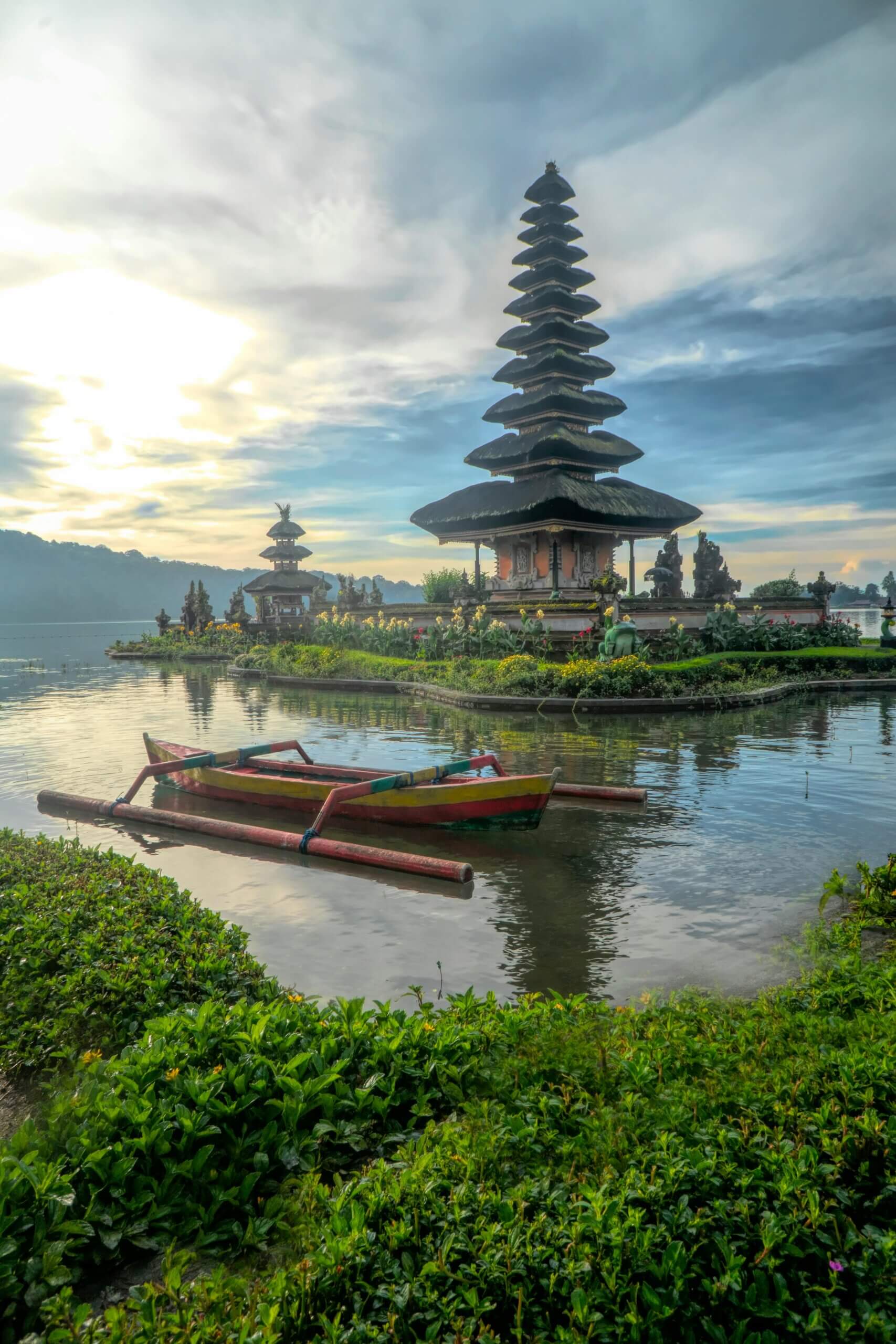 Canoe on still waters with pagoda in background in Bali